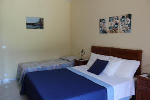 a bedroom with a bed and two ottomans at Raggio di Sole Bed & Breakfast in Macari