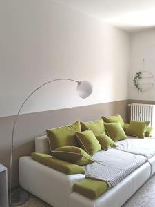 a white couch with green pillows in a room at CASA di ALE Incantevole appartamento con parcheggio gratuito in Verbania