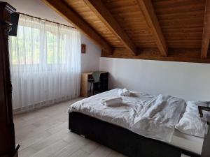 Ένα ή περισσότερα κρεβάτια σε δωμάτιο στο Pensiunea Casa de pe Vale