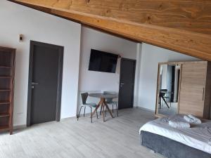 a bedroom with a bed and a table and chairs at Pensiunea Casa de pe Vale in Vulcan