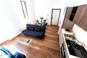 a living room with a blue couch and a table at Appartamento Vittoria in Legnano