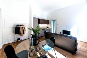 a living room with a glass table and chairs at Appartamento Vittoria in Legnano +14 photos