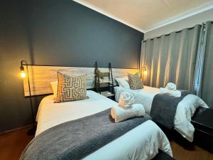 Un dormitorio con dos camas con toallas encima. en Oost Street, en Polokwane