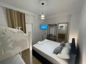 a small room with a bed and a television at Vanesa Rooms in Sarandë +17 photos