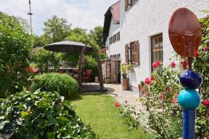 a garden with a house and an umbrella at Gästehaus Schlossblick in Bad Reichenhall