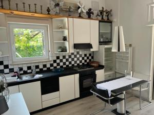 a kitchen with white cabinets and a table and a window at Art Gallery suite in Vantačići