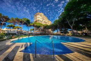 a swimming pool with a building in the background at Home Relax Calypso in Sitio de Calahonda