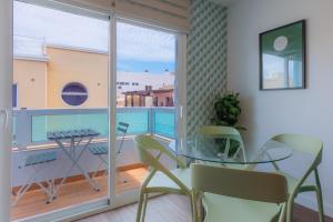 a dining room with a glass table and a balcony at Dimore Italiane - Private Suites in Corralejo