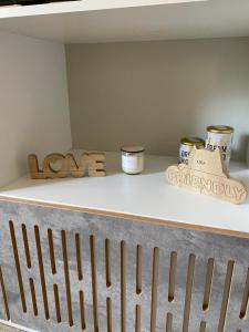 a shelf with jars and a wooden sign on it at Casa Ayacucho in Alta Gracia