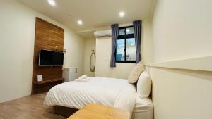 a hotel room with a bed and a tv at Full of Fun in Magong