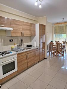 a kitchen with wooden cabinets and a table and chairs at Apartman Luka in Pula