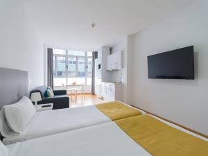 ein weißes Schlafzimmer mit großem Bett und ein Wohnzimmer in der Unterkunft Ok Las Canteras Beach by CanariasGetaway in Guanarteme