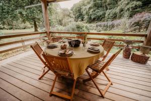 a wooden table with chairs on a wooden deck at Gîte du Bief in Pluvigner