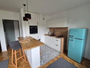 a kitchen with a blue refrigerator and a counter at Klimatyczna kawalerka w centrum No 2 in Gdynia