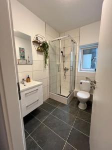 a bathroom with a shower and a toilet and a sink at Wohnen im Zentrum von Krefeld in Hubi1 in Krefeld +12 photos