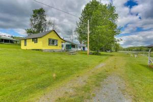 ein gelbes Haus mitten auf einem Feld in der Unterkunft Historic Honesdale Cabin on Farm and Animal Rescue! in Honesdale