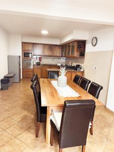 Una cocina con una mesa de madera y sillas negras. en Villa Abreu, en Ponta do Sol