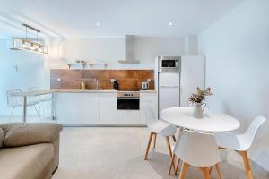 une cuisine blanche avec une table et des chaises blanches dans l'établissement Ruzafa´s Gate 3, à Valence 9 autres photos