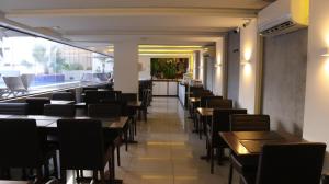 eine Reihe von Tischen und Stühlen in einem Restaurant in der Unterkunft Flat à Beira-Mar na Praia de Cabo Branco 327 in João Pessoa