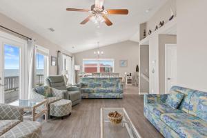 a living room with furniture and a ceiling fan at Renegade - Oceanfront and Allows Pets! in Surf City