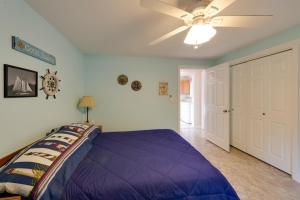 a bedroom with a purple bed and a ceiling fan at Herron Island Cabin with Deck Walk to Beach! in Lakebay +17 photos
