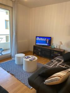 Televízia a/alebo spoločenská miestnosť v ubytovaní Parking privé gratuit, balcon, 2 chambres