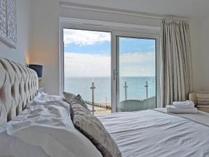 a bedroom with a bed with a view of the ocean at West Lodge, Bognor Regis in Bognor Regis