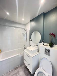 a bathroom with a toilet and a sink and a tub at Apartment HOME in Paris with View, 15min to center in Paris