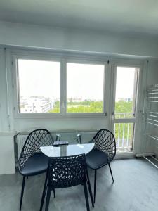 a table and chairs in a room with a window at Apartment HOME in Paris with View, 15min to center in Paris +13 photos