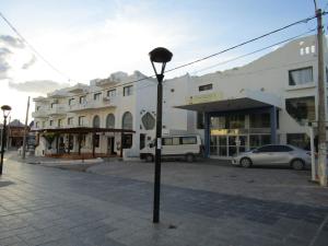 a street with cars parked in front of buildings at Departamento FORCHE 3ra Bajada al mar in Las Grutas
