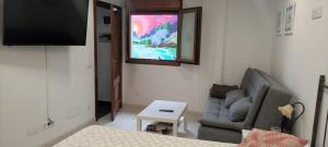 a living room with a couch and a flat screen tv at Apartamento Mar de Fora in Finisterre