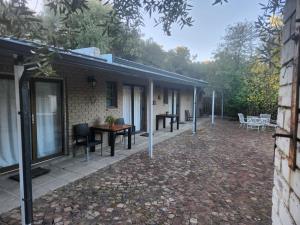 a patio of a house with a table and chairs at Mimosa Guesthouse in Colesberg