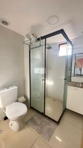 ein Badezimmer mit Toilette und Glasdusche in der Unterkunft Flat à Beira-Mar na Praia de Cabo Branco 327 in João Pessoa