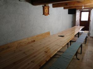 - une longue table en bois dans une pièce avec bancs dans l'établissement Rifugio San Vicino, à San Severino Marche