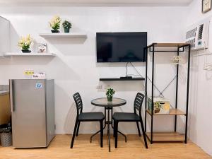a dining room with a table and chairs and a tv at Mesaverte Residences Cozy Studio Unit in Cagayan de Oro