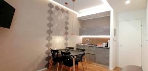 una cucina con un tavolo e sedie in una stanza di BURNÌA Sicily Holiday House a Palermo Altre 40 foto