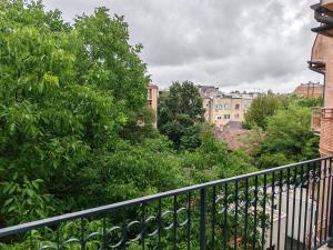 a balcony with a fence and trees and buildings at Sweet house in Novi Sad