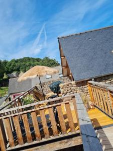 an outdoor deck with an umbrella and a building at La Passerelle de la Baie in Roz-sur-Couesnon