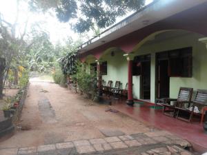 a patio of a house with chairs and tables at Walawe Park View Hotel in Udawalawe