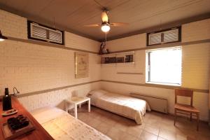 a room with two beds and a table and a window at Εξοχικό σπίτι σε κτήμα δίπλα στη θάλασσα in Mantamádos