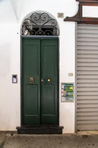 a green door on a building with a gate at Gauli casa vacanze in Chiavari