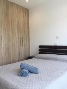 a bed with a blue towel laying on top of it at Modern 1 bedroom sea view beach apartment in Limassol