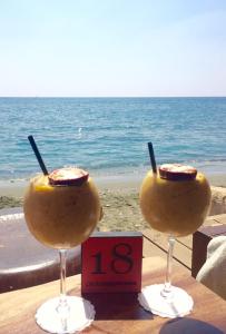 two wine glasses sitting on a table near the ocean at Modern 1 bedroom sea view beach apartment in Limassol