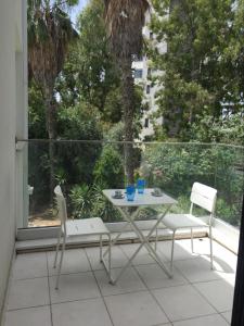a table and two chairs sitting on a balcony at Modern 1 bedroom sea view beach apartment in Limassol +4 photos