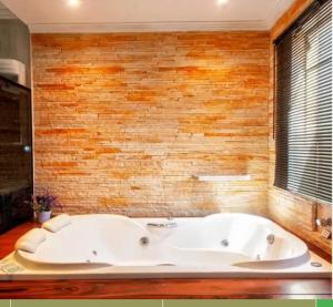a large white tub in a room with a brick wall at Pousada Bela vista Monte Verde in Monte Verde +38 photos