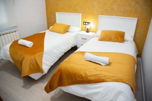 2 letti in una camera con giallo e bianco di Pregonero Urban Suites - Amarillo a Soria