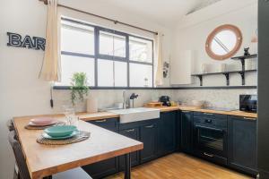 een keuken met zwarte kasten, een wastafel en een tafel bij Maison de rêve proche métro et RER in Alfortville