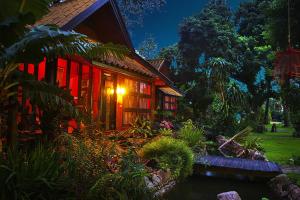 a house with red lights on the side of it at Areeya Phuree Resort Thaton in Mae Ai