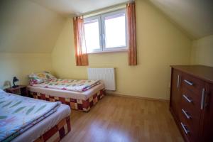 1 dormitorio con 2 camas y ventana en Privát u Raka, en Liptovský Trnovec