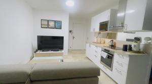 a living room with a couch and a kitchen at Joli 2 pièces tout confort Paris Parc des expositions Villepinte in Villepinte